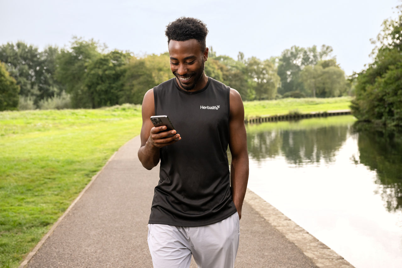 Man looking at Herbalife Business Opportunities on a cellphone outside