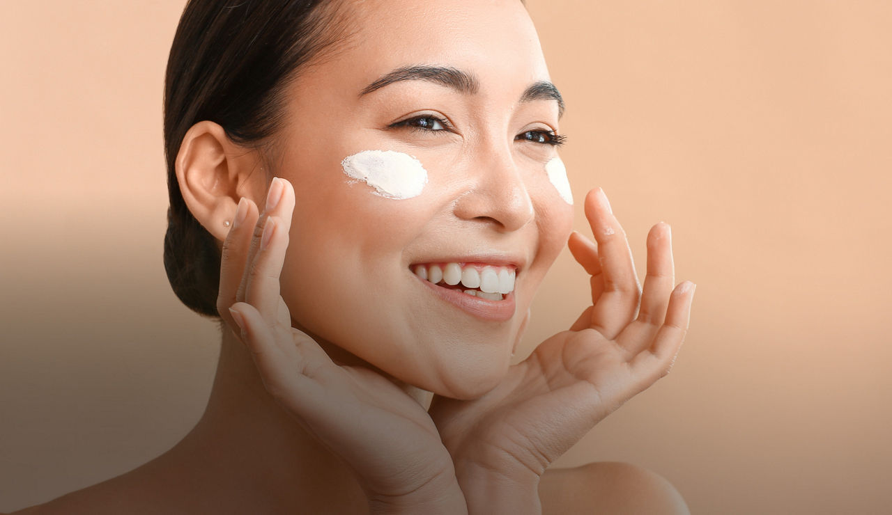 Woman applying facial cream